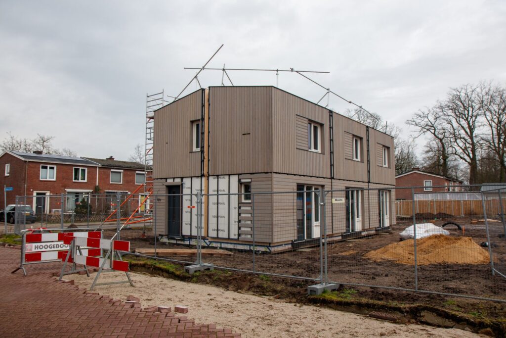 Nieuwbouwwoning in de steigers achter bouwhekken, illustratief bij de sterk verschillende bouwleges per gemeente