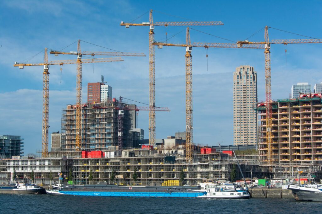 Bouwplaats met torenkranen en woningen in aanbouw, beeld bij industrieel bouwen in de woningbouw