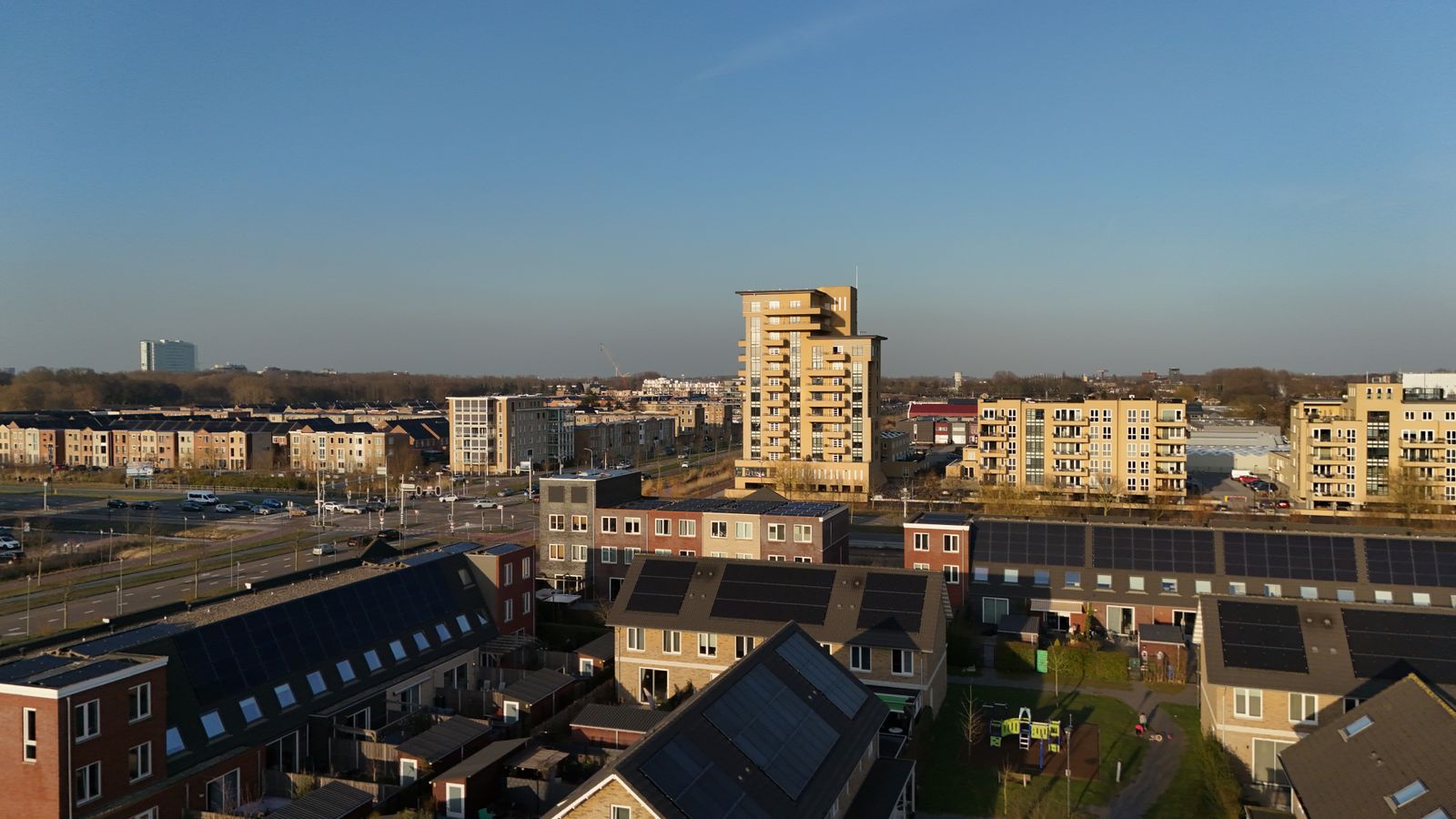 Luchtfoto van een moderne Nederlandse woonwijk met eengezinswoningen en een appartemententoren