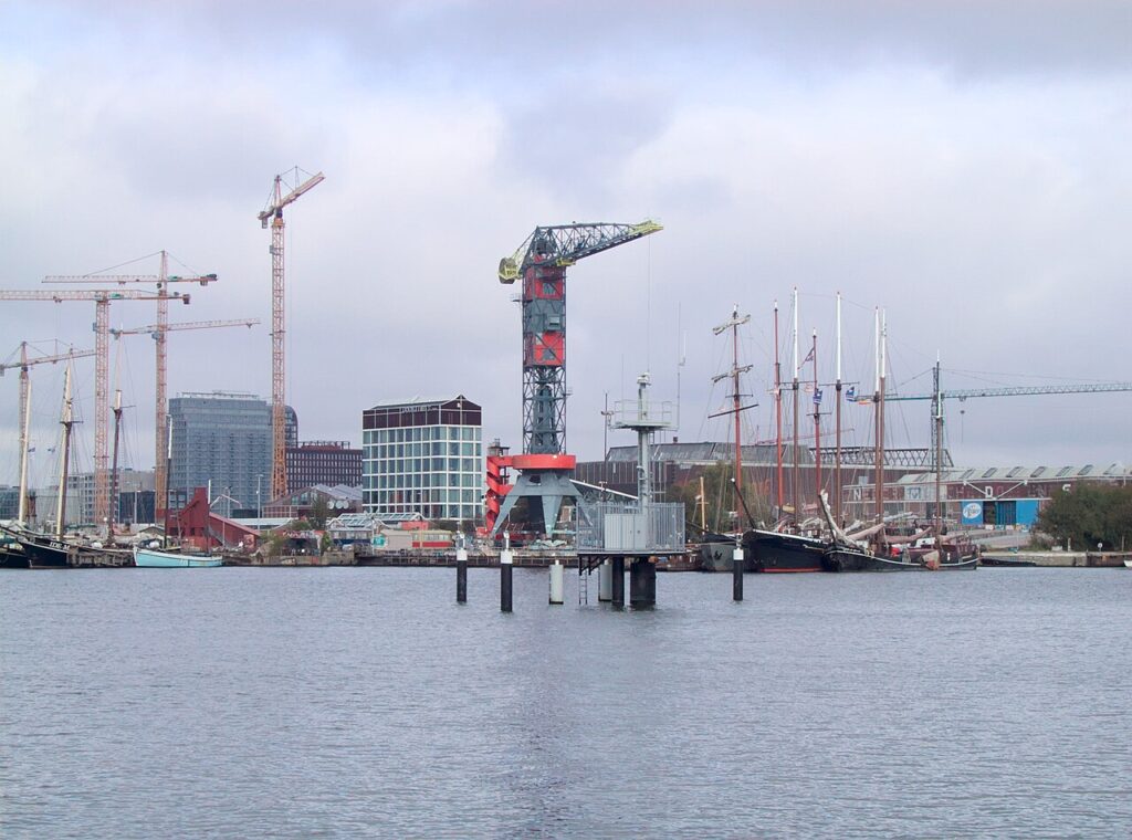 Sociale huurwoningen op de NDSM-werf in Amsterdam-Noord met bouwkranen boven het IJ