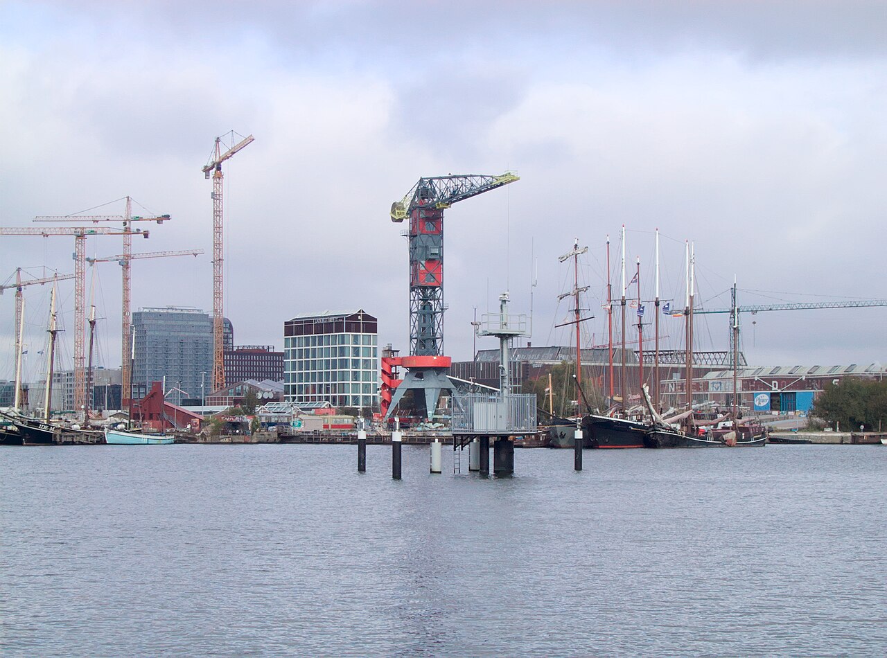 Sociale huurwoningen op de NDSM-werf in Amsterdam-Noord met bouwkranen boven het IJ