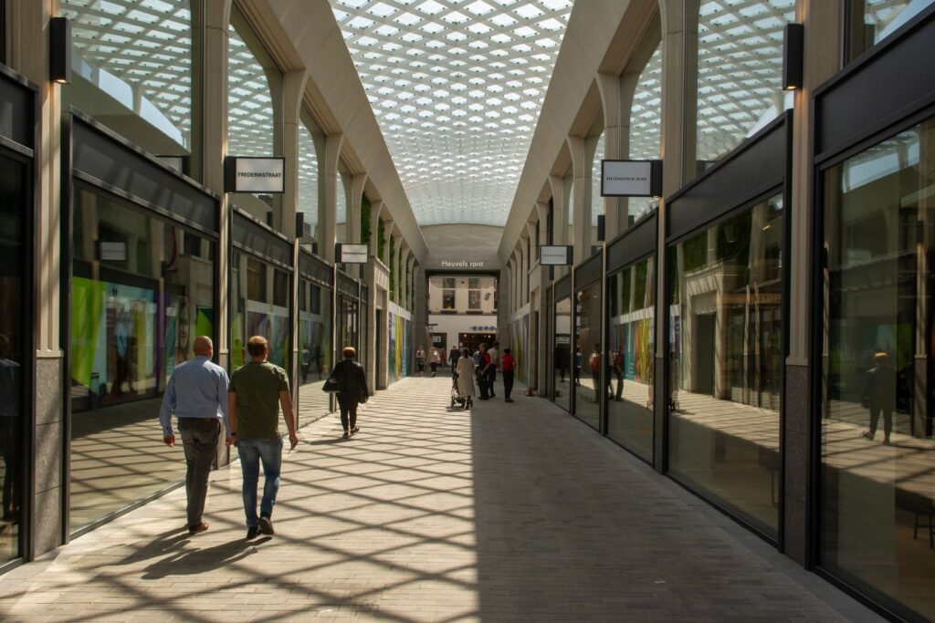 Overdekte winkelstraat met winkelend publiek, illustratief bij winkelvastgoed in Nederland
