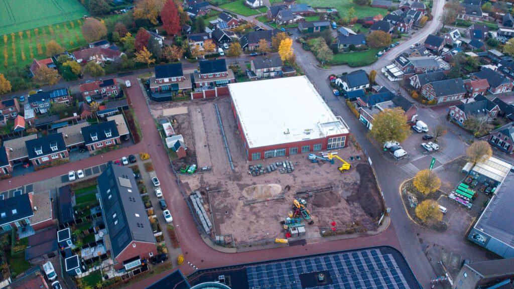 Luchtfoto van een bouwplaats in een Nederlandse woonwijk, illustratief voor stijgende woninginvesteringen
