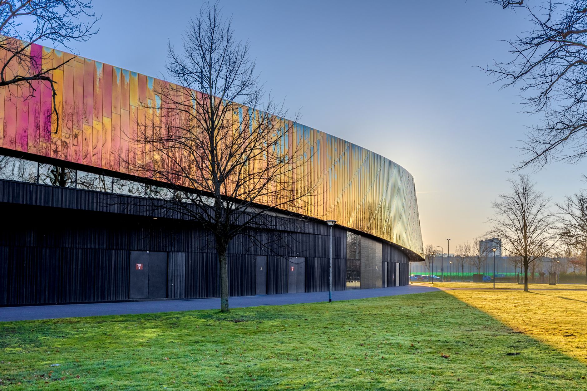 Modern multifunctioneel sportcomplex in een groene omgeving, illustratief voor het nieuwe sportcomplex op het Arenapark Hilversum