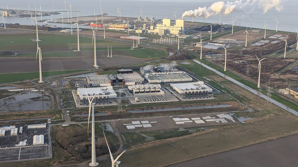 Luchtfoto van het Google-datacenter tussen windturbines in de Eemshaven, beeld bij datacentercapaciteit