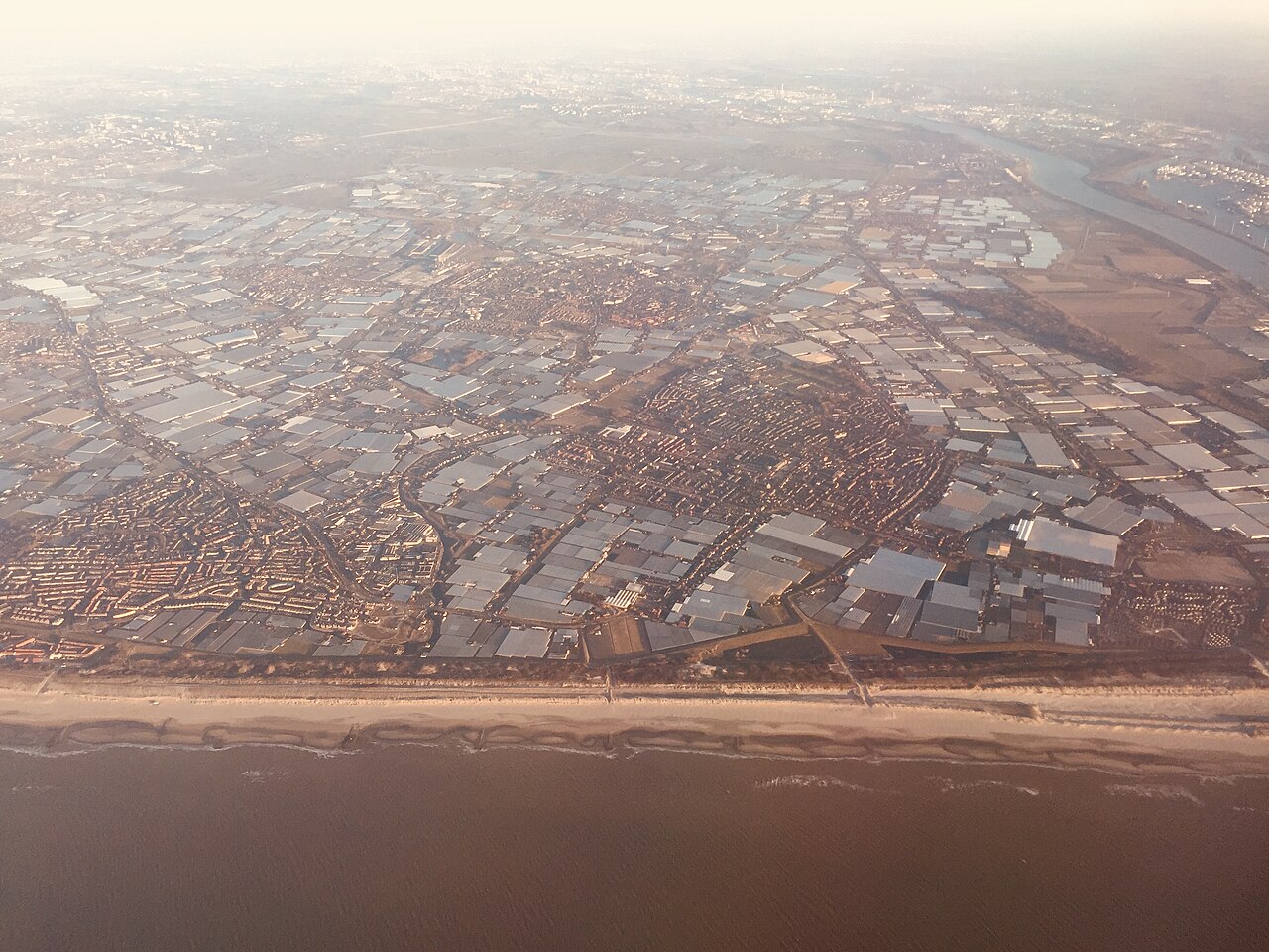 Huisvesting arbeidsmigranten: luchtfoto van kassen en woonwijken in het Westland