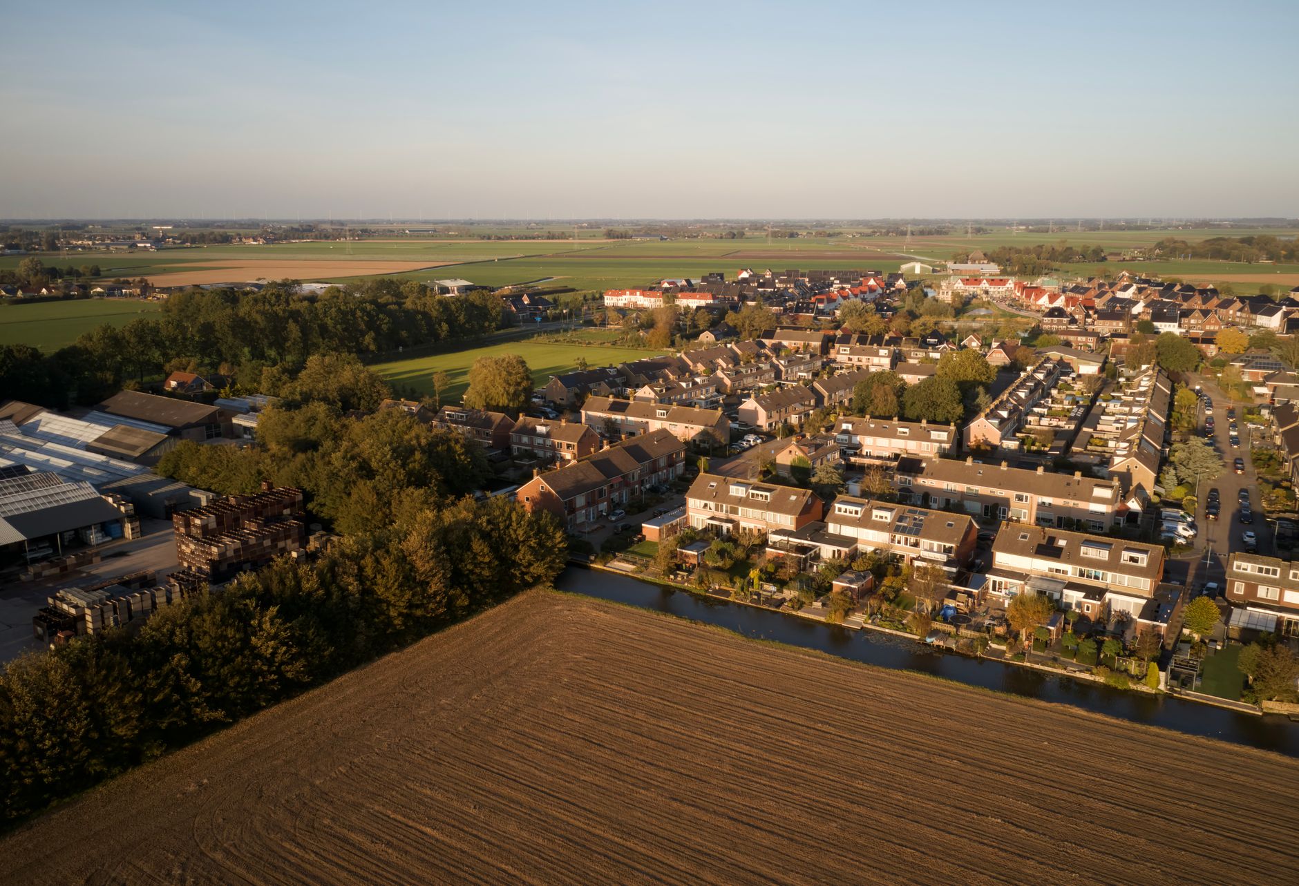 Luchtfoto van een Nederlands dorp met rijtjeswoningen, illustratief bij de stijgende huizenprijzen