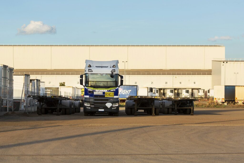 Vrachtwagen en opleggers voor een distributiecentrum, beeld bij de herfinanciering van het logistiek fonds van Delin