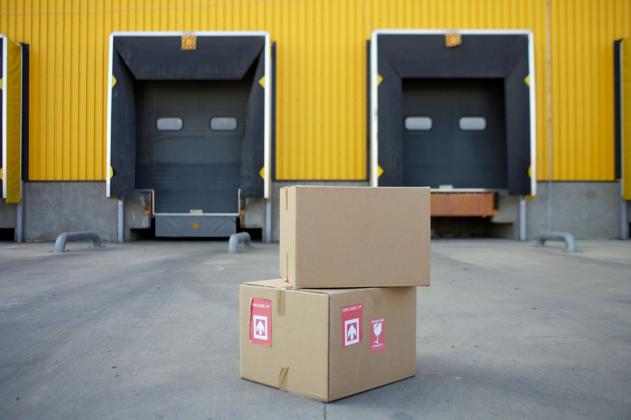 Laaddocks van een logistiek bedrijfsgebouw met dozen op de voorgrond, beeld bij logistiek vastgoed in Berkel en Rodenrijs