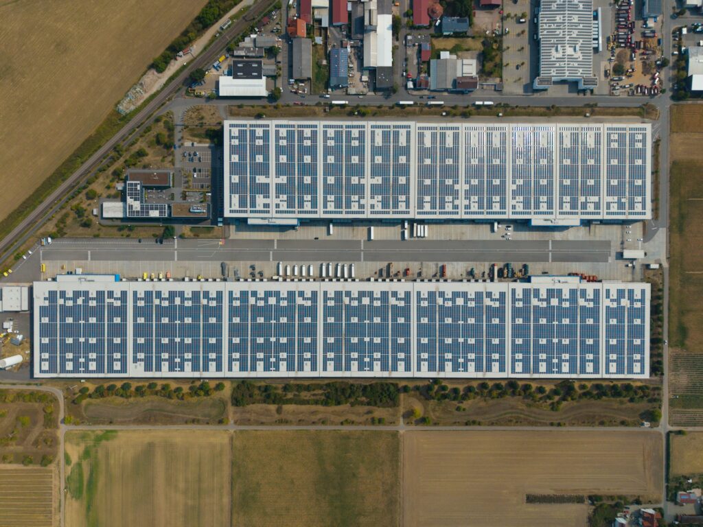 Luchtfoto van twee grote distributiecentra met zonnepanelen op het dak, beeld bij logistiek vastgoed in Tiel