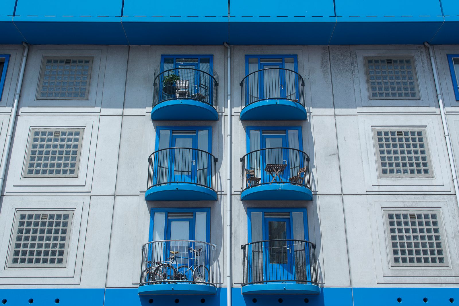 Gevel van een Nederlands appartementengebouw met blauwe balkons, beeld bij vastgoedfinanciering van huurwoningen