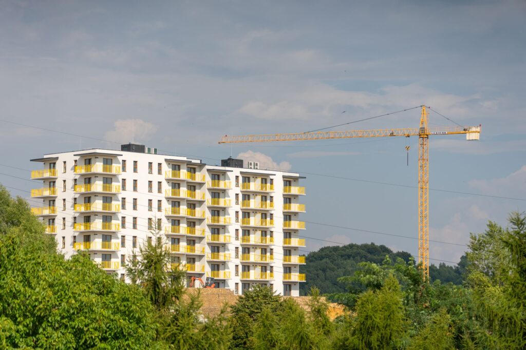 Nieuw appartementengebouw met bouwkraan, symbool voor de investeringen van woningcorporaties in nieuwbouw