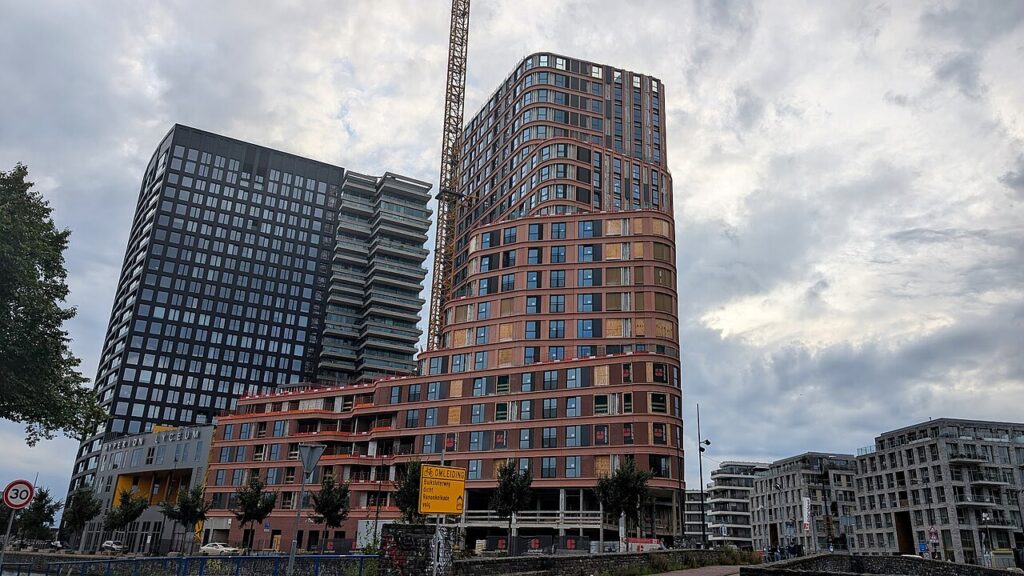 De Brinktoren in Amsterdam-Noord in aanbouw, met een bouwkraan naast de gebogen bakstenen gevel