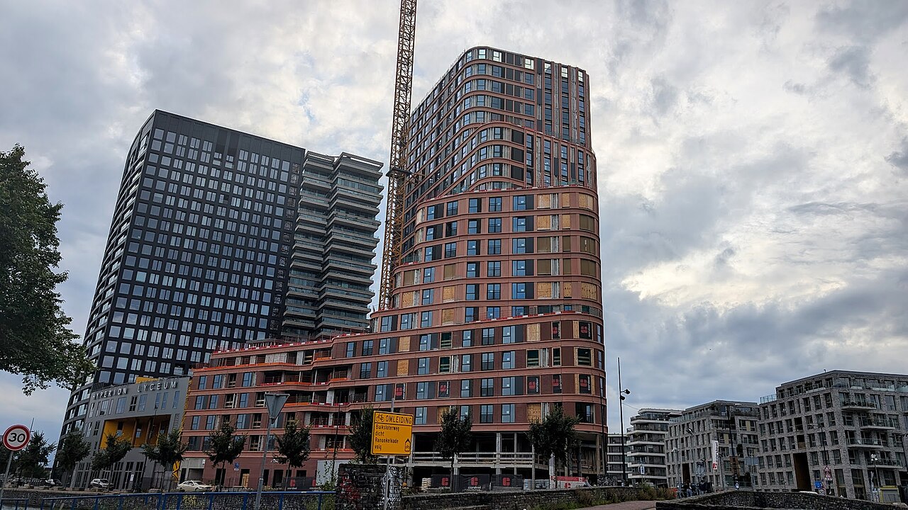 De Brinktoren in Amsterdam-Noord in aanbouw, met een bouwkraan naast de gebogen bakstenen gevel