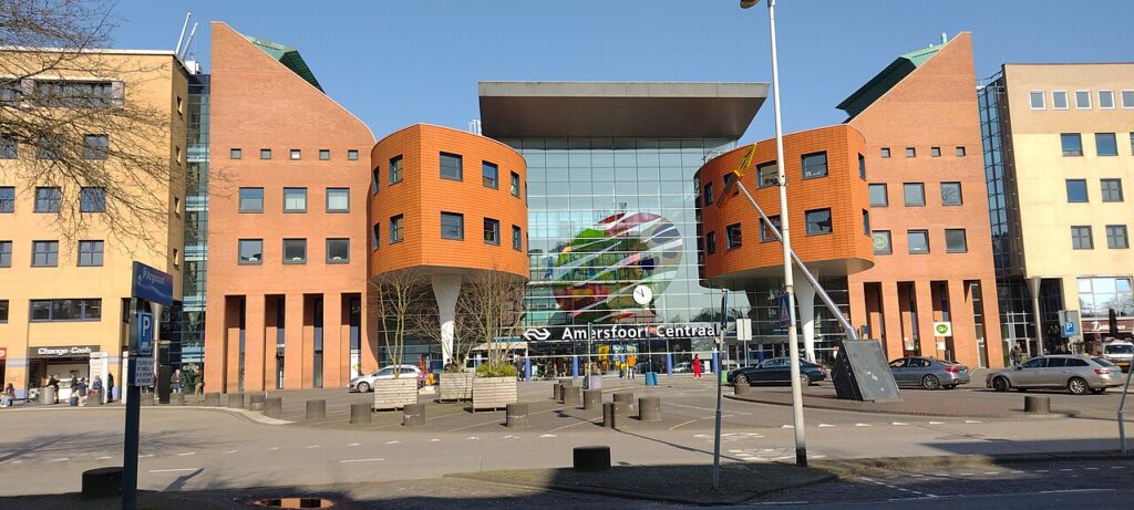 Entree van station Amersfoort Centraal met bakstenen kantoorgebouwen aan weerszijden