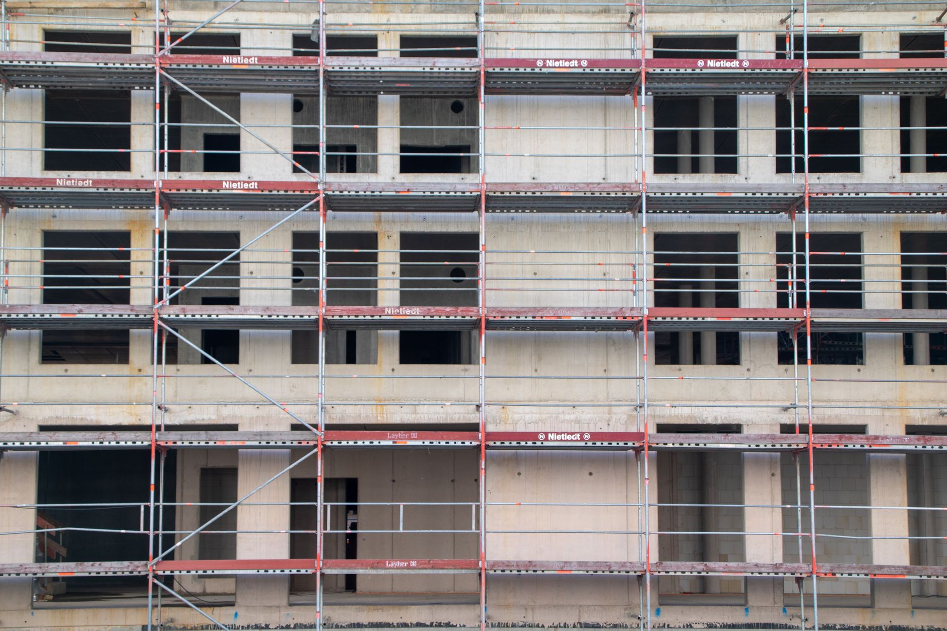 Woongebouw in aanbouw achter steigers, illustratief bij het Nationaal Expertisecentrum Woningbouw