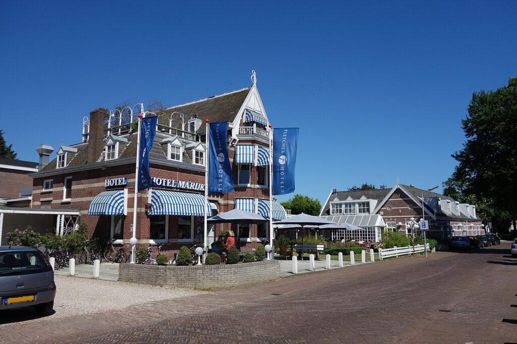 Fletcher Hotel-Restaurant Marijke in Bergen met blauw-wit gestreepte luifels en vlaggen van Fletcher Hotels