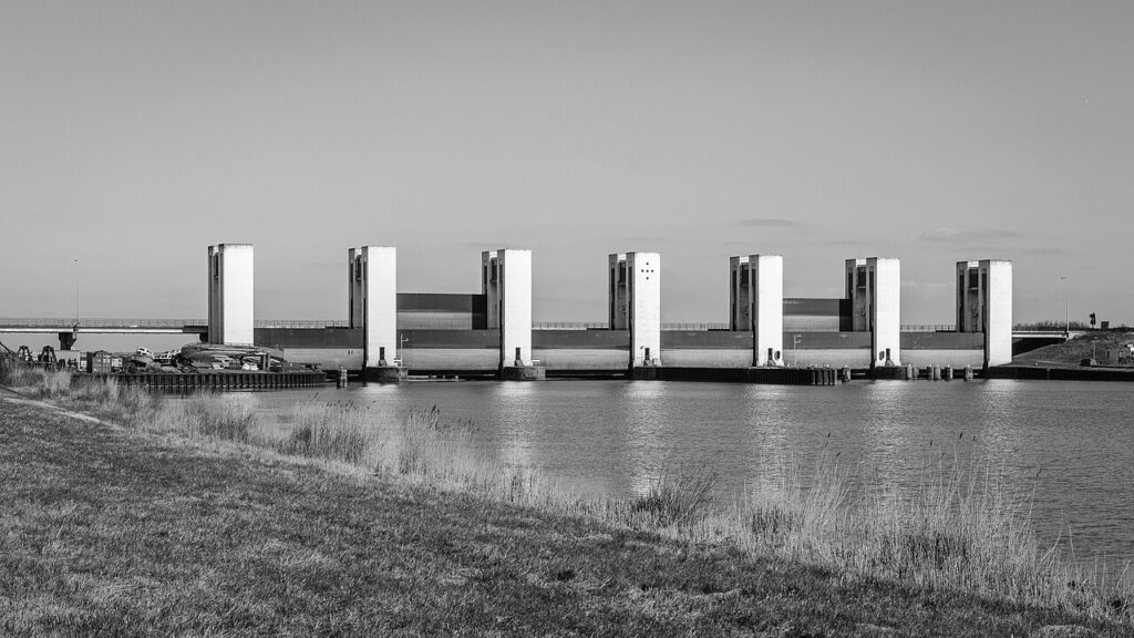De heftorens van de Houtribsluizen bij Lelystad met de brug van de N307, gezien vanaf de dijk in zwart-wit