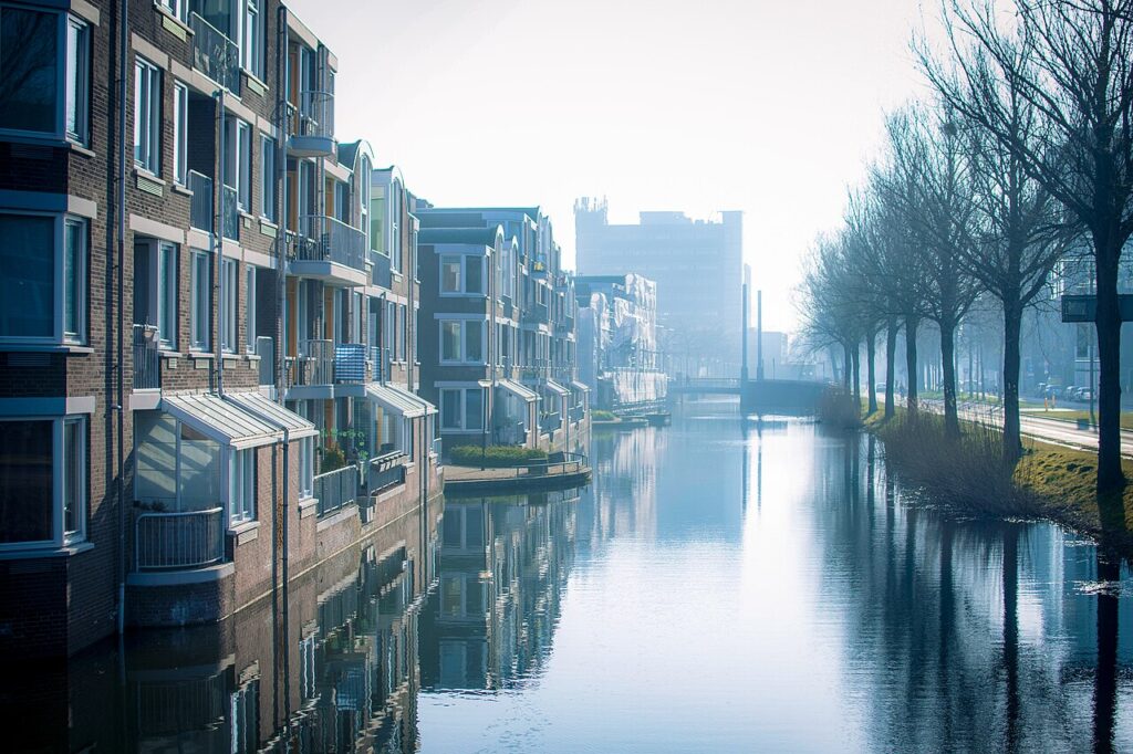 Water langs de Spuiboulevard in Dordrecht met woningen links en een kantoortoren op de achtergrond