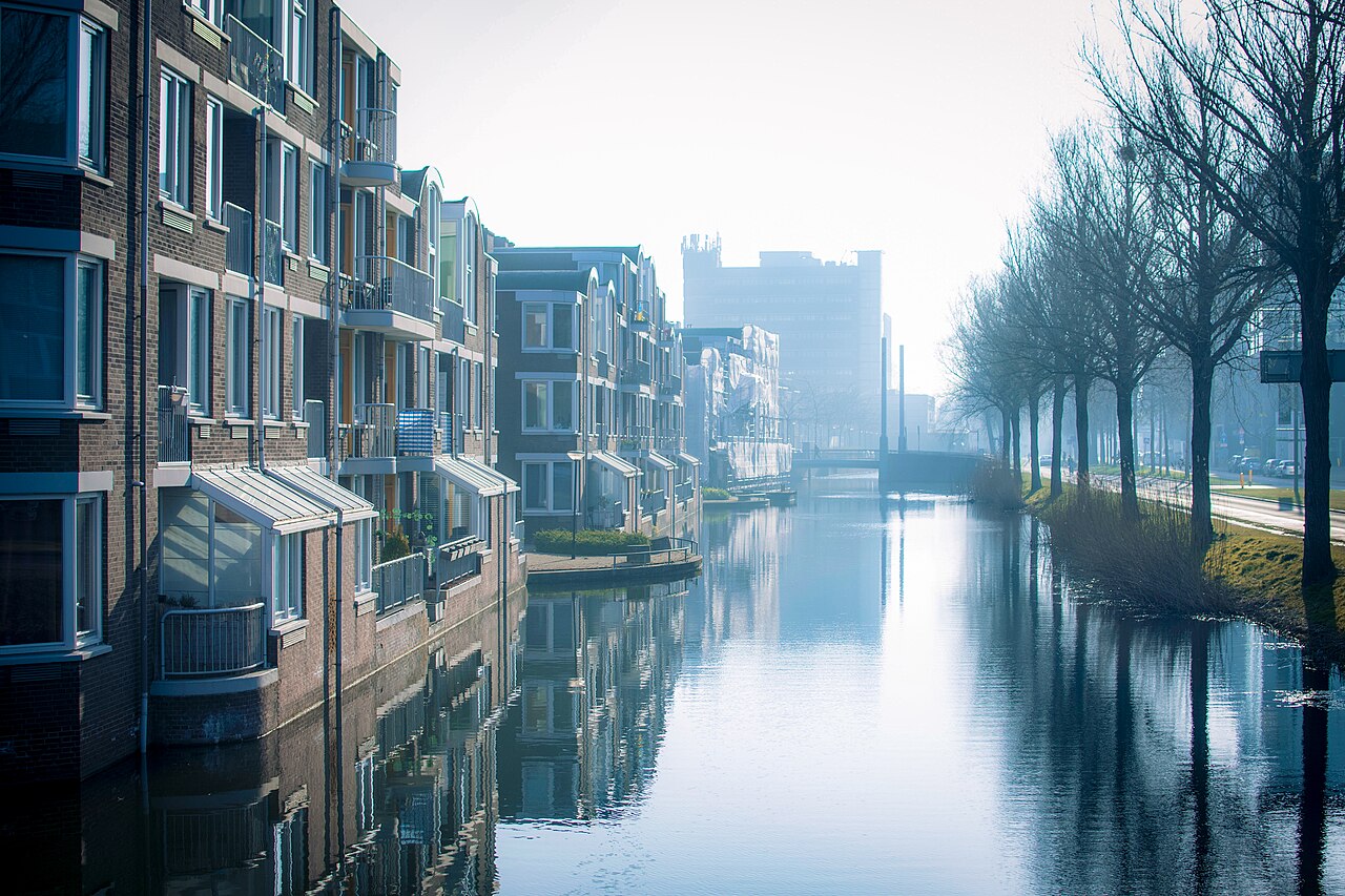 Water langs de Spuiboulevard in Dordrecht met woningen links en een kantoortoren op de achtergrond