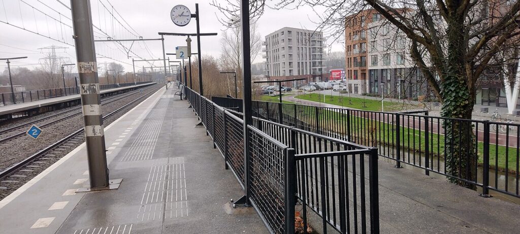 Perron van station Zaandam Kogerveld met nieuwe appartementengebouwen op de achtergrond