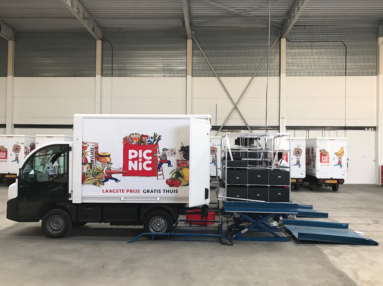 Elektrische bezorgwagens van Picnic in een distributiehal, illustratief voor een last-mile distributiecentrum