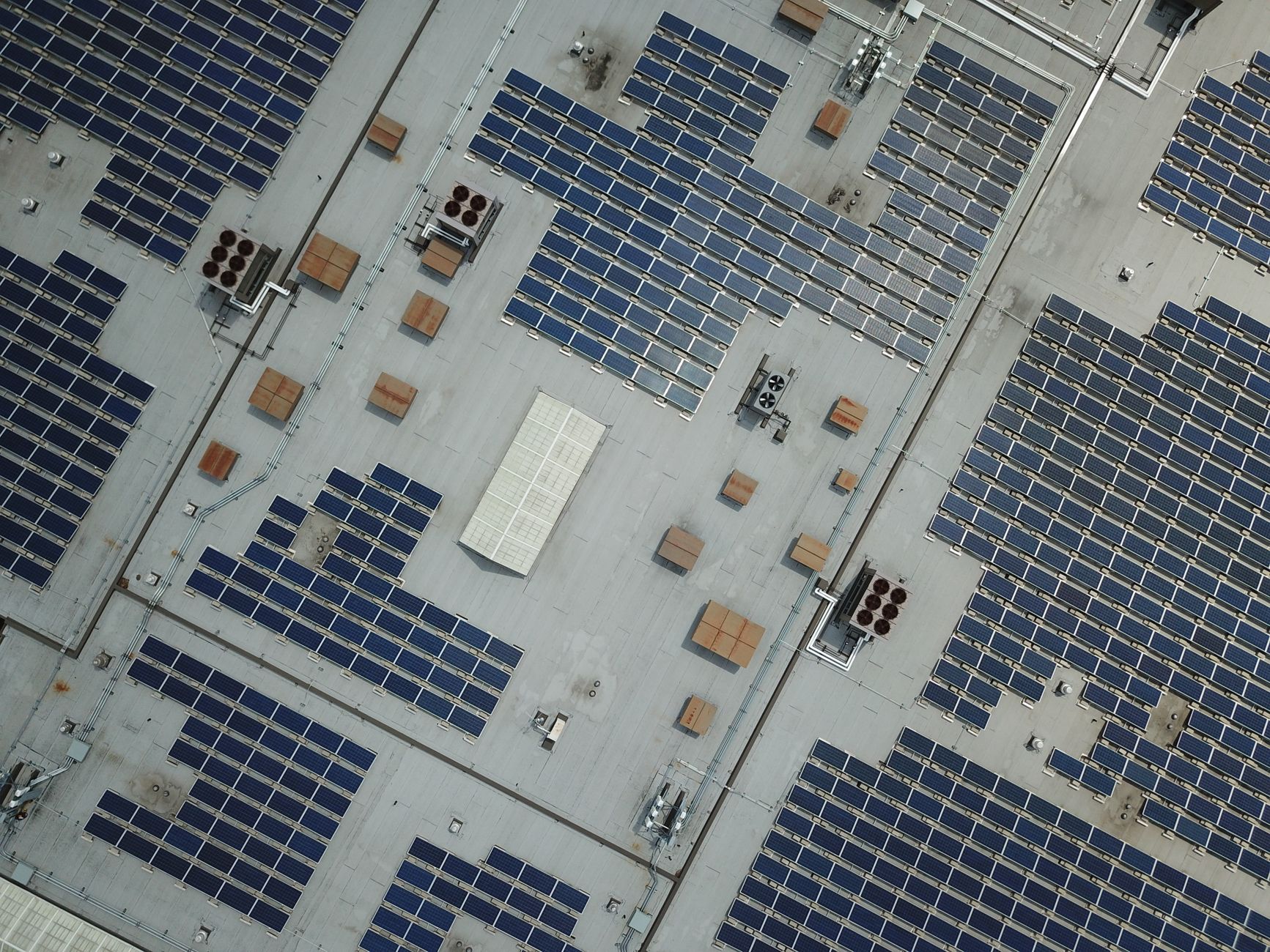 Luchtfoto van een groot bedrijfsdak met zonnepanelen, illustratief voor retrofit van logistiek vastgoed