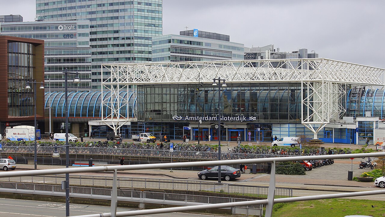 Hoofdingang van station Amsterdam Sloterdijk met kantoren op de achtergrond