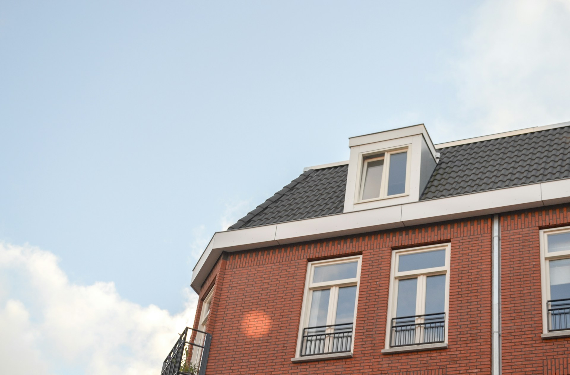 Bakstenen koopwoning met dakkapel, illustratief bij de dalende verkoop van nieuwbouwwoningen