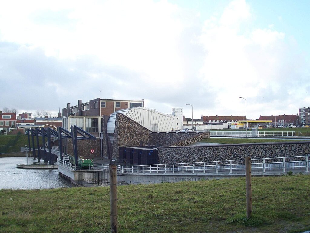 Het Koning Willem-Alexandergemaal van Rijnland in Katwijk met een natuurstenen gevel aan het water en een bakstenen gebouw erachter