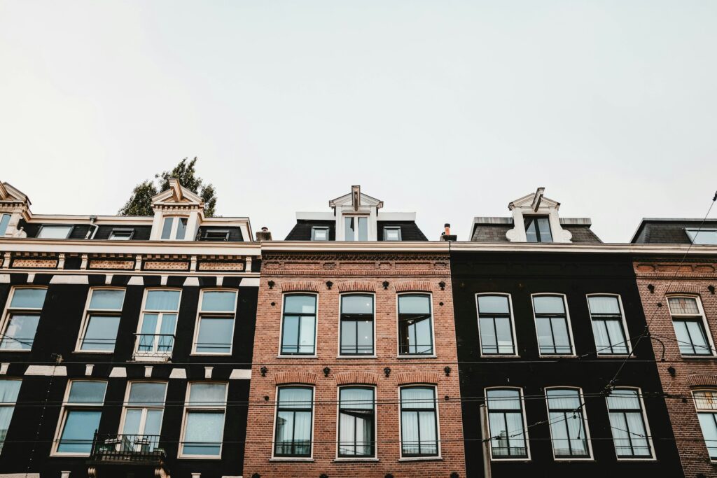 Gevels van negentiende-eeuwse woonpanden met huurwoningen in een Amsterdamse straat