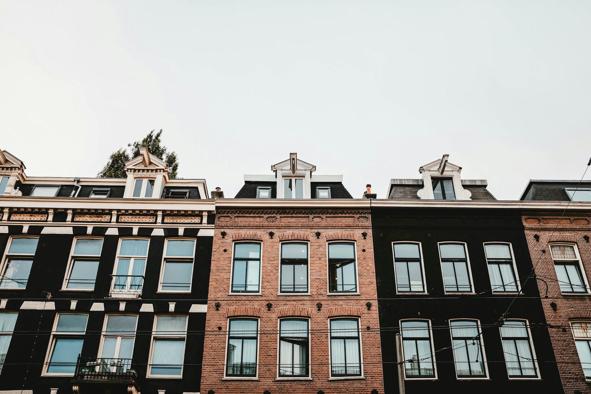 Gevels van negentiende-eeuwse woonpanden met huurwoningen in een Amsterdamse straat