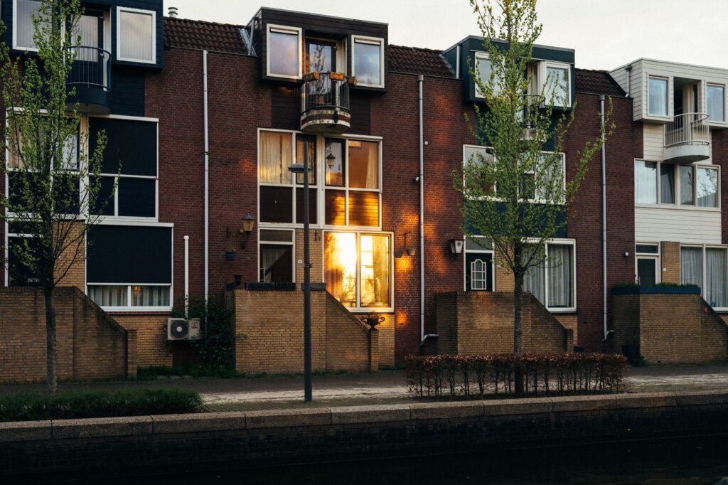 Rij eengezinswoningen met voortuinen aan een gracht in Almere bij zonsondergang
